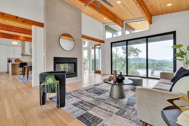 18408 F M Road 1431, Jonestown, TX 78645 - living area featuring a multi sided fireplace, a ceiling fan, a wooden ceiling with exposed beams, light wood-style floors, and recessed lighting