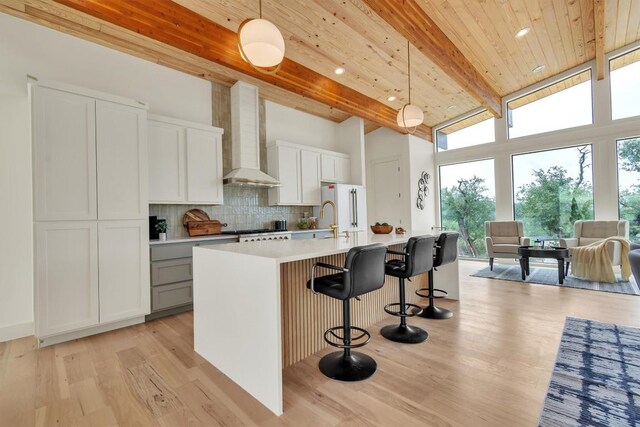 18408 F M Road 1431, Jonestown, TX 78645 - kitchen featuring wall chimney range hood, freestanding refrigerator, decorative backsplash, high vaulted ceiling, and light countertops