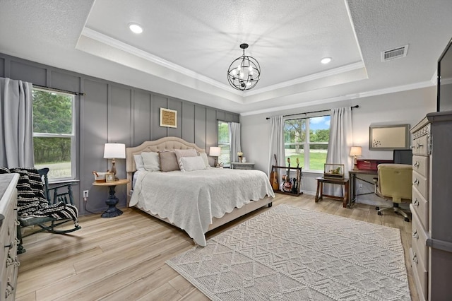 16240 Toby Ct, Temple, TX 76502 - bedroom featuring a raised ceiling, light wood-type flooring, ornamental molding, a desk, and a chandelier