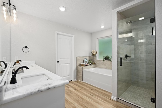 16240 Toby Ct, Temple, TX 76502 - full bath featuring wood finished floors, a bath, a shower stall, and double vanity