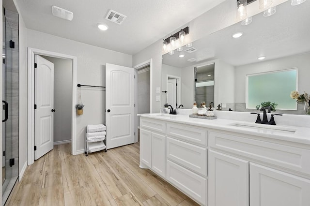 16240 Toby Ct, Temple, TX 76502 - bathroom featuring a shower stall, double vanity, wood finished floors, and recessed lighting