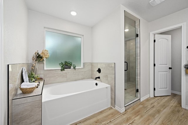 16240 Toby Ct, Temple, TX 76502 - bathroom with wood finished floors, a garden tub, a shower stall, and baseboards