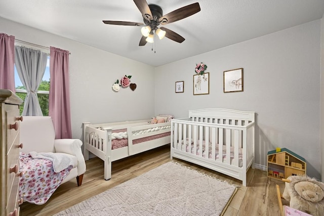16240 Toby Ct, Temple, TX 76502 - bedroom featuring wood finished floors, a ceiling fan, and a nursery area