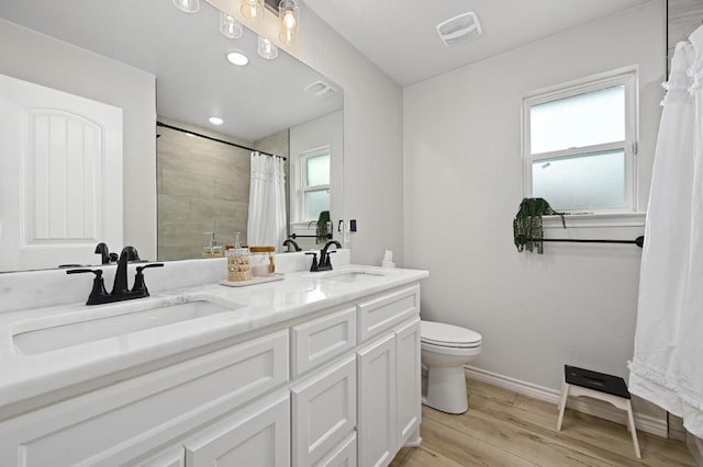 16240 Toby Ct, Temple, TX 76502 - full bathroom with wood finished floors, toilet, tiled shower, baseboards, and double vanity
