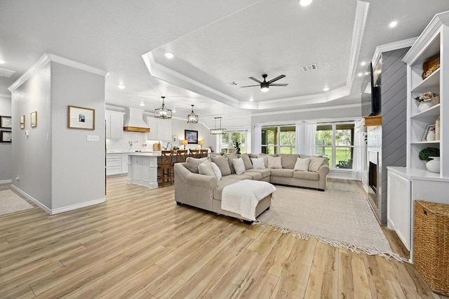 16240 Toby Ct, Temple, TX 76502 - living room with a raised ceiling, ceiling fan, light wood-style flooring, ornamental molding, and recessed lighting