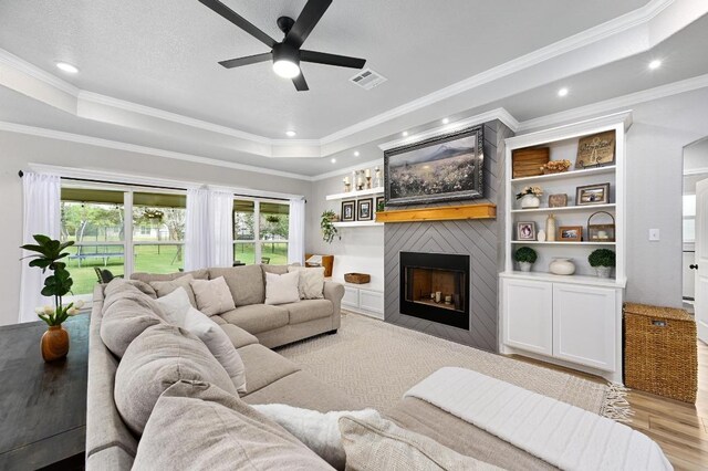 16240 Toby Ct, Temple, TX 76502 - living area with a ceiling fan, wood finished floors, a raised ceiling, recessed lighting, and a large fireplace