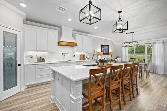 16240 Toby Ct, Temple, TX 76502 - kitchen featuring a sink, custom exhaust hood, ornamental molding, a chandelier, and black electric stovetop