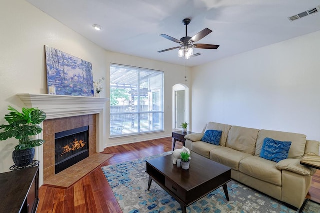 4308 Clear Meadow Pl, Round Rock, TX 78665 - living area with a tile fireplace, wood finished floors, ceiling fan, arched walkways, and baseboards