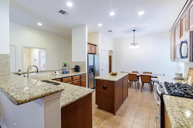 4308 Clear Meadow Pl, Round Rock, TX 78665 - kitchen featuring appliances with stainless steel finishes, a sink, a center island, a peninsula, and a chandelier