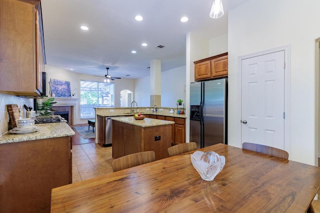 4308 Clear Meadow Pl, Round Rock, TX 78665 - kitchen with stainless steel appliances, a peninsula, ceiling fan, a fireplace, and recessed lighting