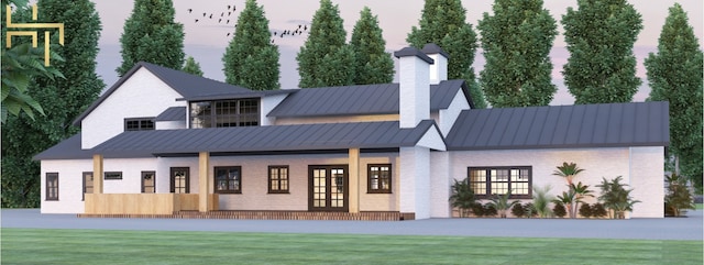 141 Hill Cv, Dripping Springs, TX 78620 - rear view of house featuring a standing seam roof, metal roof, a chimney, a lawn, and brick siding