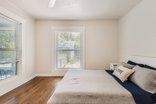1202 Loma Dr, Austin, TX 78741 - bedroom with wood finished floors, multiple windows, ornamental molding, a ceiling fan, and baseboards