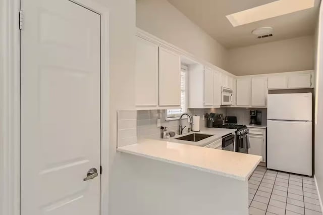 1202 Loma Dr, Austin, TX 78741 - kitchen with appliances with stainless steel finishes, a sink, light countertops, tasteful backsplash, and white cabinetry