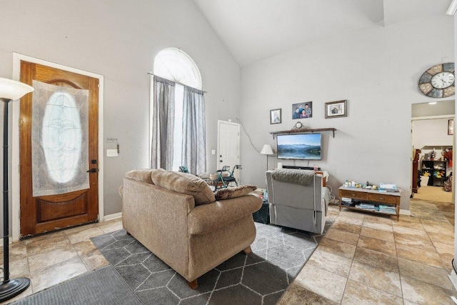 156 Kaeleku Ln, Bastrop, TX 78602 - living room featuring high vaulted ceiling, healthy amount of natural light, stone tile floors, and baseboards