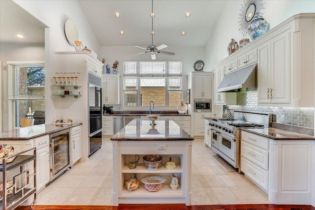 6012 Messenger Stake, Austin, TX 78746 - kitchen with range with two ovens, under cabinet range hood, wine cooler, open shelves, and vaulted ceiling