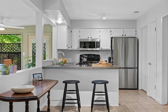 4839 Canyonbend Cir, Austin, TX 78735 - kitchen featuring stainless steel appliances, a sink, a peninsula, white cabinetry, and light tile patterned floors