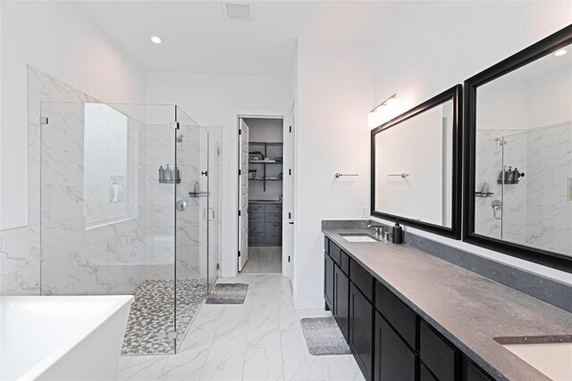 216 Reata Ridge Loop, Liberty Hill, TX 78642 - full bathroom featuring a marble finish shower, double vanity, a soaking tub, a walk in closet, and marble look tile flooring