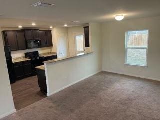 11605 Claudette St, San Antonio, TX 78252 - kitchen with baseboards, black microwave, recessed lighting, carpet flooring, and a peninsula