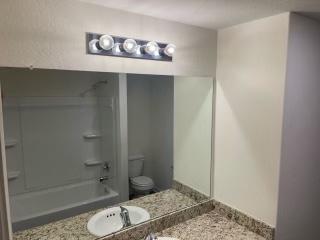 11605 Claudette St, San Antonio, TX 78252 - bathroom with toilet, vanity, and washtub / shower combination