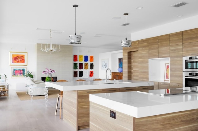 1337 Spyglass Dr, Austin, TX 78746 - kitchen featuring modern cabinets, a spacious island, a sink, double oven, and brown cabinetry