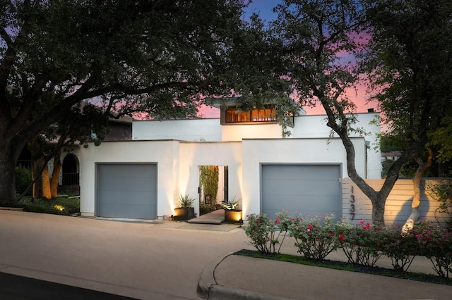 1337 Spyglass Dr, Austin, TX 78746 - view of front of home featuring stucco siding, an attached garage, and concrete driveway
