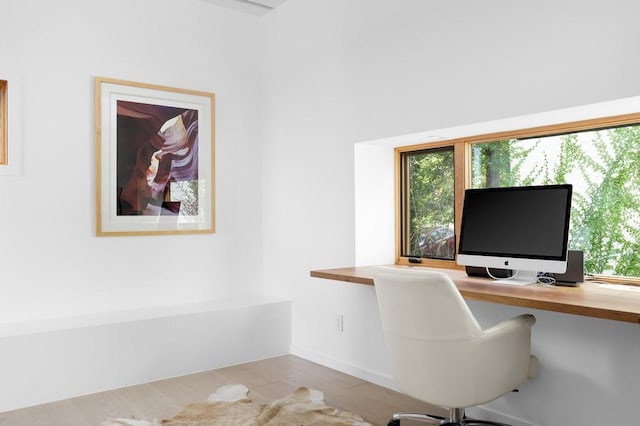 1337 Spyglass Dr, Austin, TX 78746 - office area featuring built in desk, wood finished floors, and baseboards