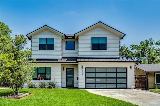 3004 Hunt Trl, Austin, TX 78757 - view of front of property with a standing seam roof, a front yard, driveway, an attached garage, and metal roof