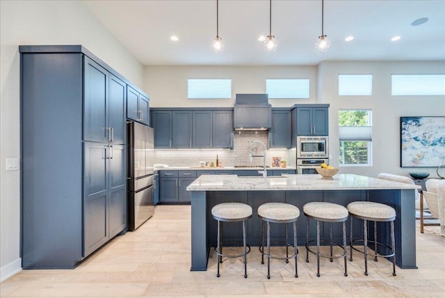 3004 Hunt Trl, Austin, TX 78757 - kitchen featuring stainless steel appliances, light stone countertops, a kitchen bar, backsplash, and recessed lighting