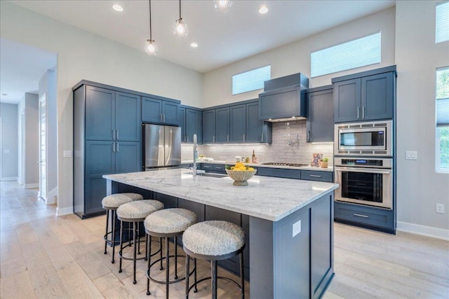3004 Hunt Trl, Austin, TX 78757 - kitchen featuring appliances with stainless steel finishes, a sink, light stone counters, baseboards, and decorative backsplash