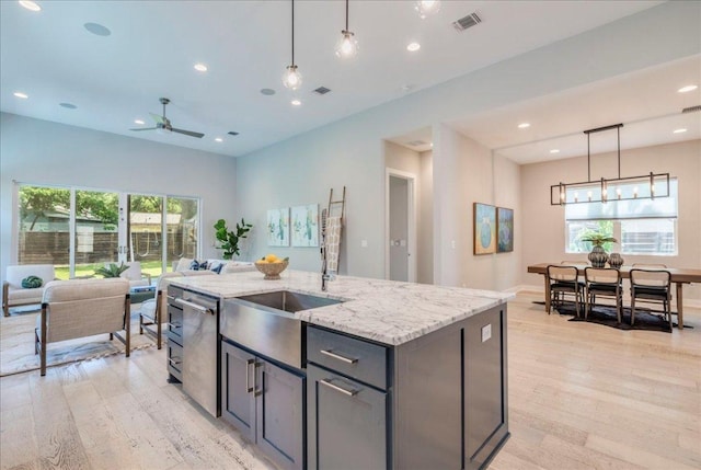 3004 Hunt Trl, Austin, TX 78757 - kitchen with stainless steel dishwasher, open floor plan, light wood-style floors, ceiling fan, and recessed lighting