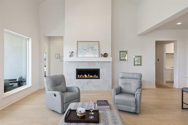 19401 Summit Glory Trl Unit 80, Spicewood, TX 78669 - living area featuring a high ceiling, a fireplace, light wood-type flooring, baseboards, and recessed lighting