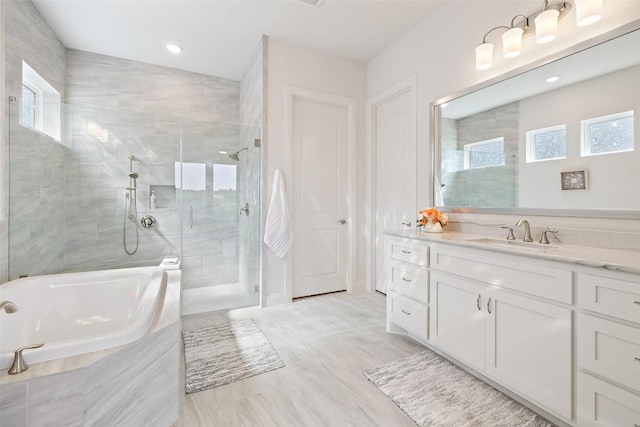 19401 Summit Glory Trl Unit 80, Spicewood, TX 78669 - bathroom with plenty of natural light, a shower stall, a tub, vanity, and recessed lighting