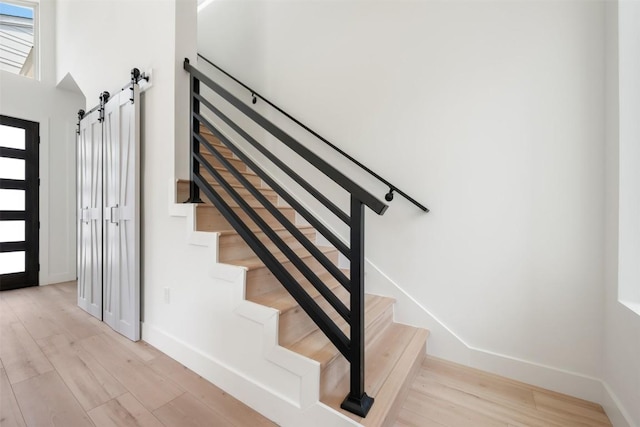 106 W Croslin St Unit B, Austin, TX 78752 - stairway featuring a barn door, baseboards, wood finished floors, and plenty of natural light