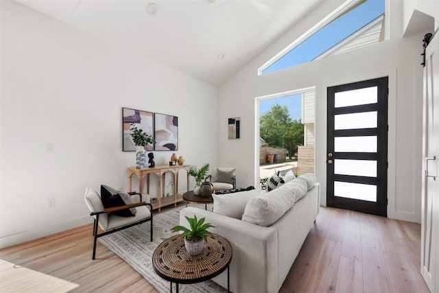 106 W Croslin St Unit B, Austin, TX 78752 - living area featuring a barn door, light wood-style floors, baseboards, and high vaulted ceiling