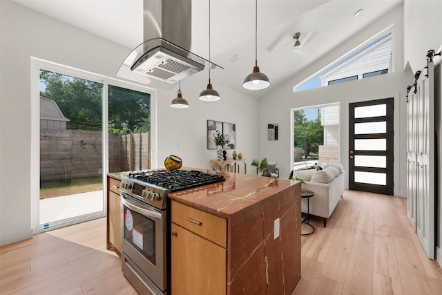 106 W Croslin St Unit B, Austin, TX 78752 - kitchen with stainless steel range with gas cooktop, range hood, a center island, light wood-type flooring, and a barn door