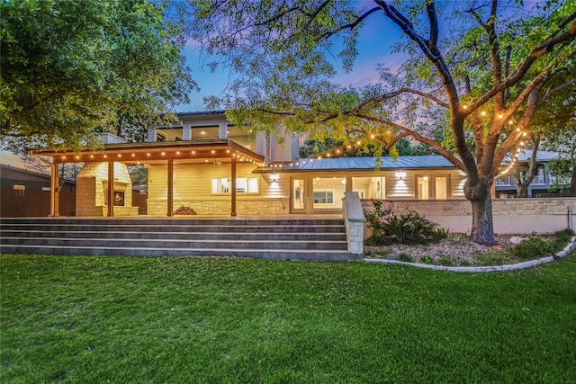 1704 Bluebonnet Ln, Kingsland, TX 78639 - back of property at dusk with a lawn and covered porch