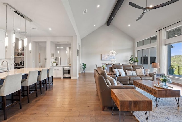 158 Baldovino Skwy, Lakeway, TX 78738 - living area with beverage cooler, ceiling fan, beam ceiling, light wood-style floors, and high vaulted ceiling