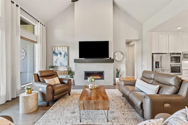158 Baldovino Skwy, Lakeway, TX 78738 - living room featuring high vaulted ceiling, a tiled fireplace, and wood finished floors