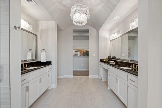158 Baldovino Skwy, Lakeway, TX 78738 - full bath with a chandelier, two vanities, baseboards, and vaulted ceiling
