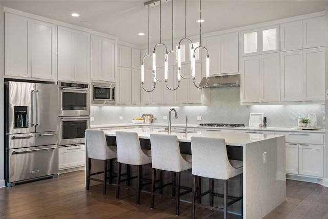 158 Baldovino Skwy, Lakeway, TX 78738 - kitchen with appliances with stainless steel finishes, a sink, dark wood-style flooring, white cabinets, and recessed lighting