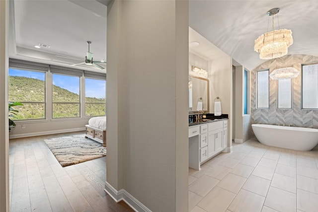 158 Baldovino Skwy, Lakeway, TX 78738 - ensuite bathroom with vanity, a freestanding bath, ceiling fan, baseboards, and a chandelier