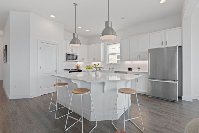 425 Dayridge Dr, Dripping Springs, TX 78620 - kitchen with appliances with stainless steel finishes, dark wood finished floors, white cabinetry, a center island, and recessed lighting