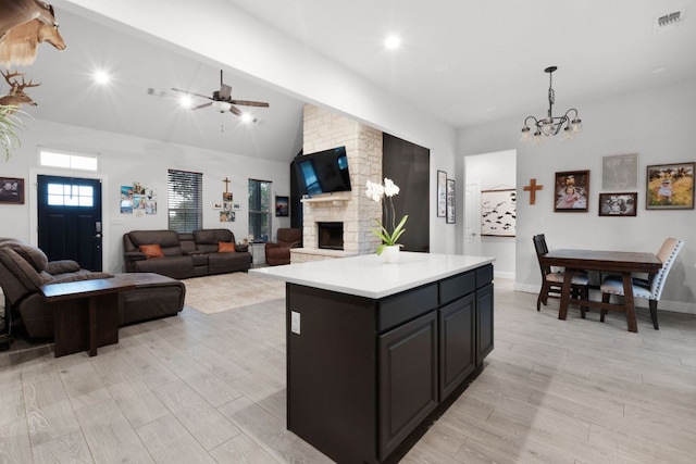 110 Lakecliff Cv, Kingsland, TX 78639 - kitchen featuring light wood-style flooring, light countertops, a fireplace, a chandelier, and a center island