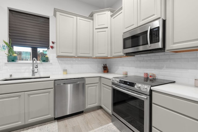110 Lakecliff Cv, Kingsland, TX 78639 - kitchen with appliances with stainless steel finishes, a sink, light countertops, and decorative backsplash