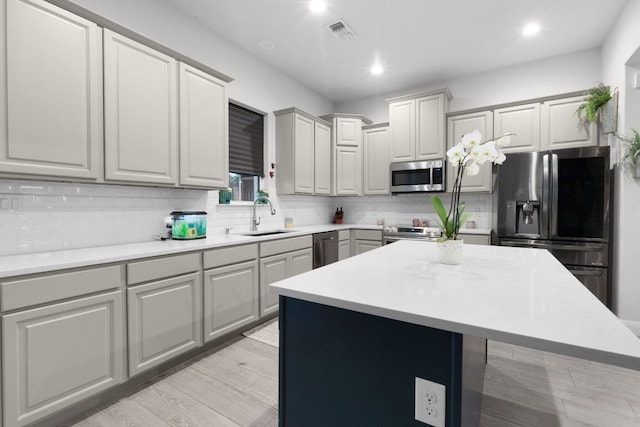 110 Lakecliff Cv, Kingsland, TX 78639 - kitchen with appliances with stainless steel finishes, a sink, decorative backsplash, light countertops, and recessed lighting