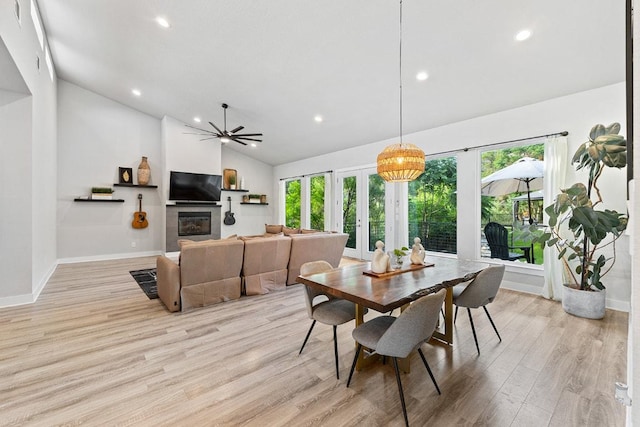 20702 Post Oak Dr, Lago Vista, TX 78645 - dining area with light wood-style flooring, recessed lighting, a glass covered fireplace, high vaulted ceiling, and baseboards