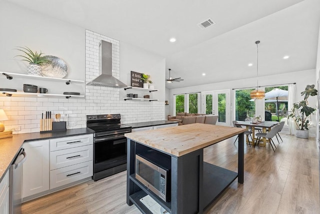 20702 Post Oak Dr, Lago Vista, TX 78645 - kitchen with open shelves, stainless steel appliances, wall chimney exhaust hood, decorative backsplash, and light wood-type flooring