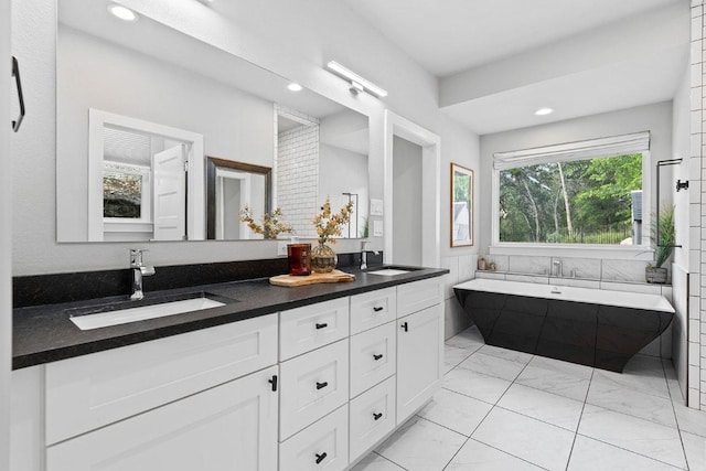 20702 Post Oak Dr, Lago Vista, TX 78645 - bathroom featuring marble look tiles, double vanity, a soaking tub, and recessed lighting