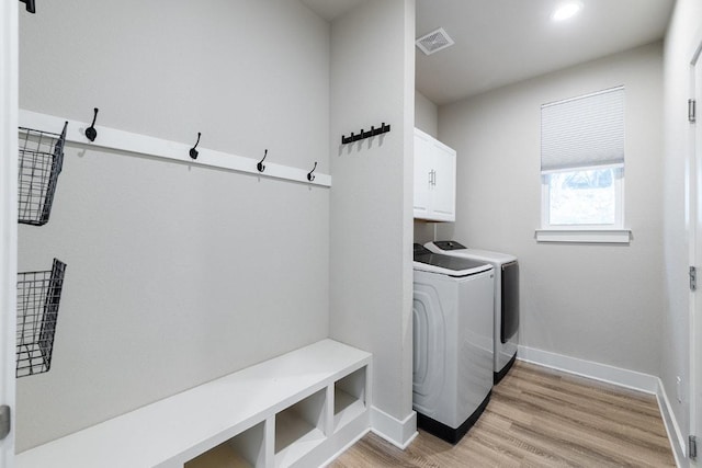 20702 Post Oak Dr, Lago Vista, TX 78645 - washroom with cabinet space, independent washer and dryer, baseboards, and light wood finished floors