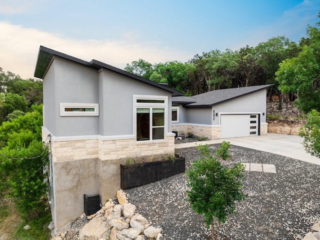 20702 Post Oak Dr, Lago Vista, TX 78645 - contemporary house with stone siding, concrete driveway, a garage, and stucco siding